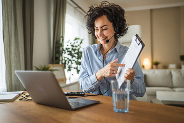 call center female agent wearing headset talk to client on video call