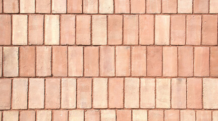 Close-up full-frame classic red brick wall, fired clay bricks arranged in a uniform horizontal pattern. Textured surface and rustic tone. Masonry style, minimalist brick background, wallpaper. 