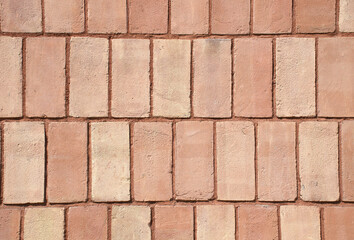 Close-up full-frame classic red brick wall, fired clay bricks arranged in a uniform horizontal...