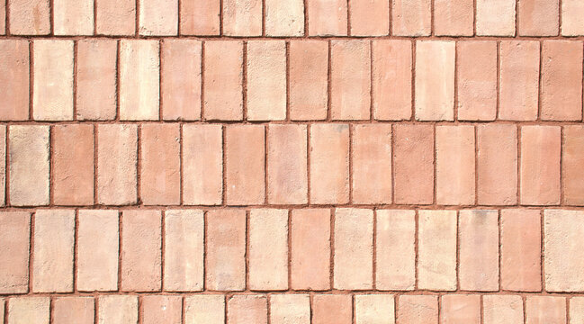 Close-up full-frame classic red brick wall, fired clay bricks arranged in a uniform horizontal pattern. Textured surface and rustic tone. Masonry style, minimalist brick background, wallpaper. 