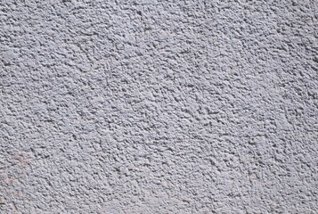 Fototapeta premium Close-up full frame gray stucco image, wall background, rough, grainy texture. Concrete surface natural irregularities, backgrounds, architectural construction-related design. Urban plaster wall.