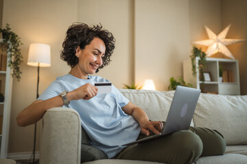 Obraz premium happy mature woman buy online use laptop and credit card at home