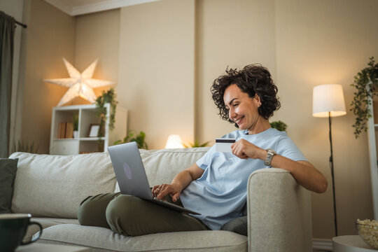 happy mature woman buy online use laptop and credit card at home