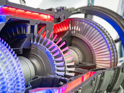 Close-up of a jet engine turbine section with detailed metal blades and colored lighting, showcasing aerospace technology and engineering. &ndash; Aerospace, Engineering