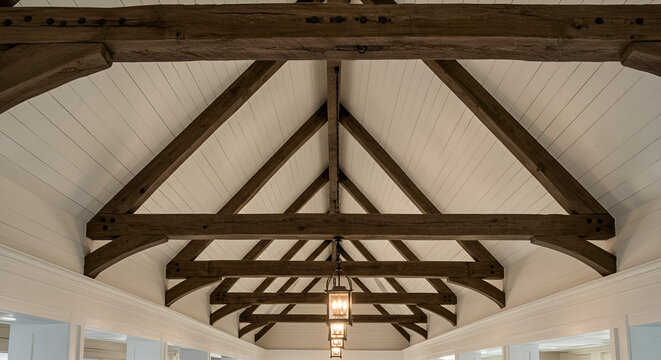 
 A vaulted ceiling with exposed, weathered wooden beams, white shiplap in between, and hanging lantern-style pendant lights.