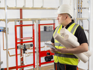 Man designer engineering communications. Engineer in worker vest with papers. Man inspector...