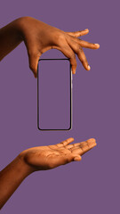 Black african hands holding lifting Mobile smart phone and showing blank screen to camera over purple background. product mockup template
