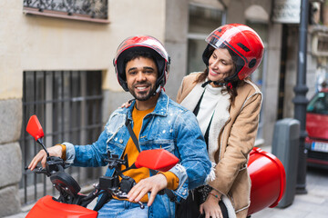 Naklejka premium Latin American Couple Driving Motorcycle in the City.
