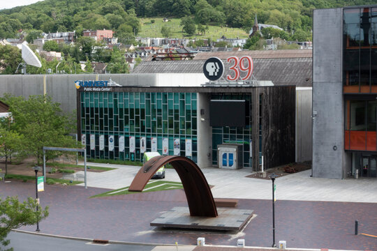 Bethlehem, PA - US - May 25, 2025 Modern PBS 39 and UNIVEST Public Media Center building with glass fa&ccedil;ade, arch sculpture out front, and green hills providing a scenic backdrop.