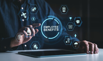 Businessman interacting with virtual employee benefits icons and digital symbols on futuristic interface above tablet on dark background.