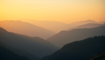 Layered mountain silhouettes fade into a warm orange sky during a hazy, tranquil sunset vista.