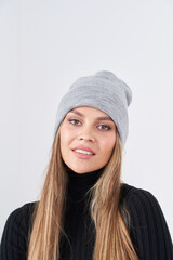 Fototapeta premium Beautiful woman wearing a gray beanie and black sweater with a cheerful smile