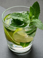 Refreshing mojito cocktail with lime, mint, and ice on dark background