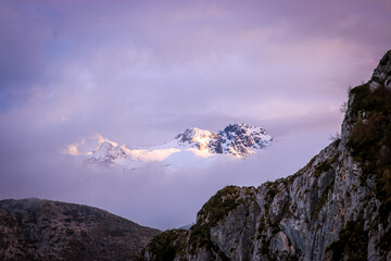 Mystical Snowy Mountain Peak Framed by Rugged Rocks at Dawn