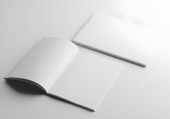Two blank books, one open and one closed, displayed on a light surface with soft, diffused lighting.