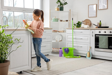 Cute girl cleaning counter in kitchen