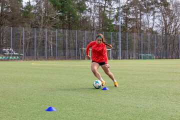 Obraz premium Girl on the soccer field. Soccer training. Active lifestyle. Football concept.
