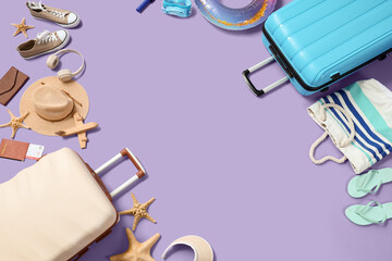 Suitcases with beach accessories, inflatable ring, passport and headphones on purple background