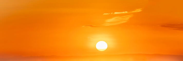 Spectacular sunrise on the horizon with the sea at your feet. Romantic sunrise. Beach sunrises. The sun tries to rise through the clouds in the orange sunrise. Travel and landscape concept.