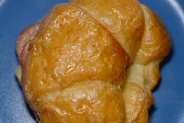 Stack of croissants on a bakery tray with soft natural light.