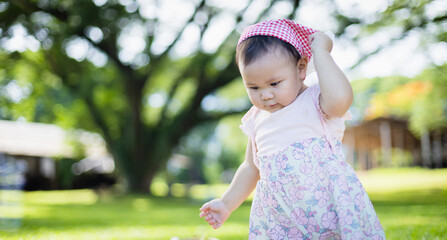 Young child enjoys leisure time outdoors during family picnic with people around in peaceful park concept capturing innocence and playfulness