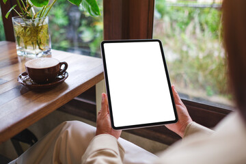 Mockup image of a woman holding digital tablet with blank white desktop screen