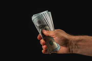 Hand holding cash in a dark environment at night