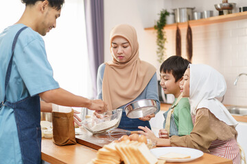 Asian muslim woman and lovely children are preparing and cooking in the kitchen.