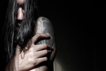 Depressed Long-Haired Man with Skull Tattoo in Dark Emotional Portrait