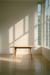 Sunlight streams through a large window illuminating a light wood table in a minimalist room.  The walls are white and the floor is light wood