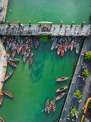 Aerial View of Colorful Wooden Boats Docked Along River Bridge in Hoi An