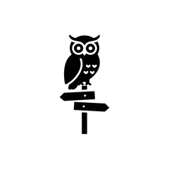 Owl sitting on a signpost in a night-time setting