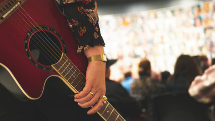 A person playing holding a guitar music close up detail instrument