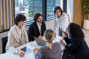 Asian woman sale manager is showing annual report to her colleague in executive meeting for next year plan with market share increase for global business and investment