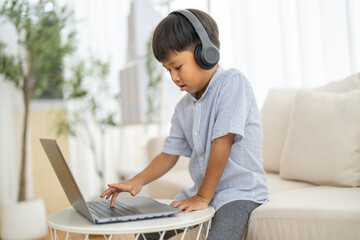 Asian boy using laptop with headphones course online learning, distance education for kids,...