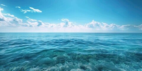 A serene blue ocean with gentle waves and a clear sky with fluffy white clouds