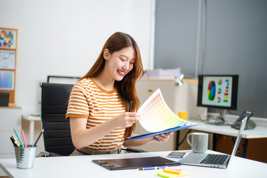 Young designer using digital tablet and laptop while planning creative project. Ideal for freelance design, UX UI, remote work
