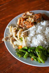Nasi Rames, Central Java, Indonesia, captured on June 2, 2025. A traditional mixed rice dish served with a variety of side dishes such as vegetables, tempeh, egg, and spiced meats.
