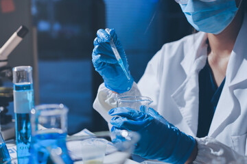 Scientist pipetting medical samples into microplate in laboratory