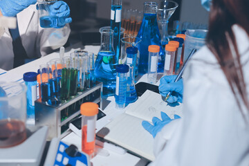 Scientist pipetting medical samples into microplate in laboratory