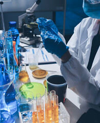 Scientist pipetting medical samples into microplate in laboratory