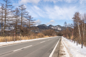Empty road with snow mountain view and snow covered on roadside in winter season