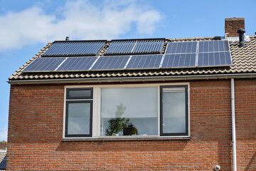 Row house with solar panels and heat pipes on roof in Oosterland village