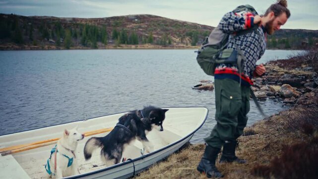 A Person With His Dogs Going Down The Rowing Boat From A Lake. Static Shot