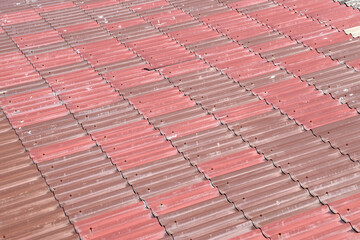 grunge red-brown tiles roof panel under sunlight