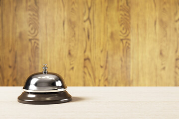 Classic service bell on wooden counter with blurred wood panel background in warm lighting, symbolizing hotel reception concept. 3D Rendering