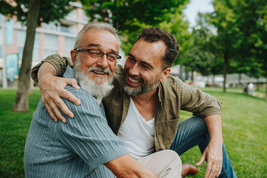 Fototapeta Portrait of handsome mature man and his older father hugging each other.