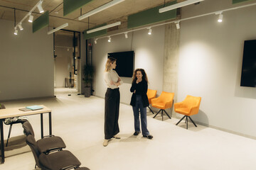 Professional Discussion Between Two Women in a Modern Office Space