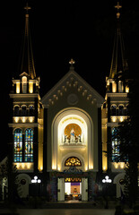 The Catholic Church Cathedral at night, illuminated by warm yellow light. Serene and picturesque view of the landmark. View of Ba Lang Church, Nha Trang city Vietnam. Travel photo. 