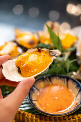 Nha Trang, Vietnam. Oyster grilled in cheese being served at local restaurant.